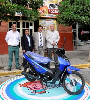 Autoridades de Lotería del Chubut, junto a la moto que se sorteará esta noche en el Mini Telebingo